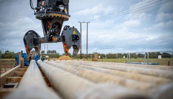 A machine gripping, and ready to lift, pipes